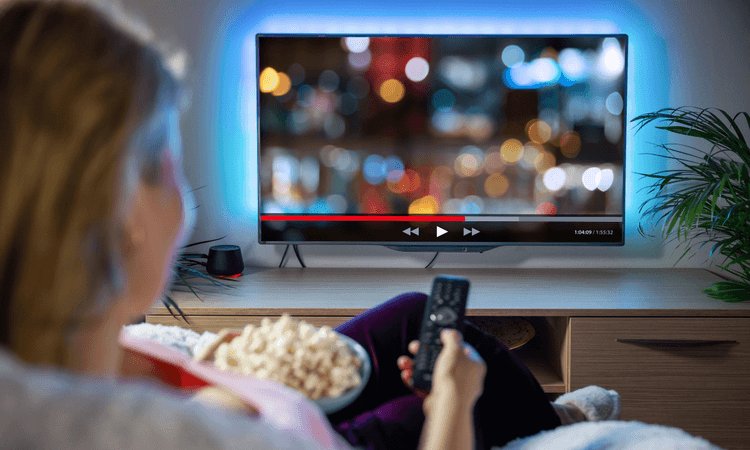 一個女性拿著遙控器看電視