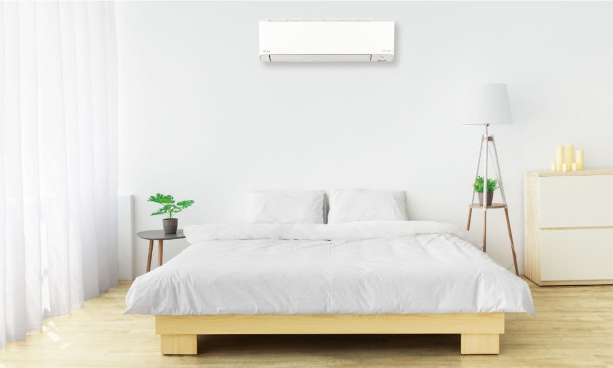 安裝在臥室牆上的大金冷氣,搭配簡約風格木質家具與白色床鋪,打造清新舒適的居家空間